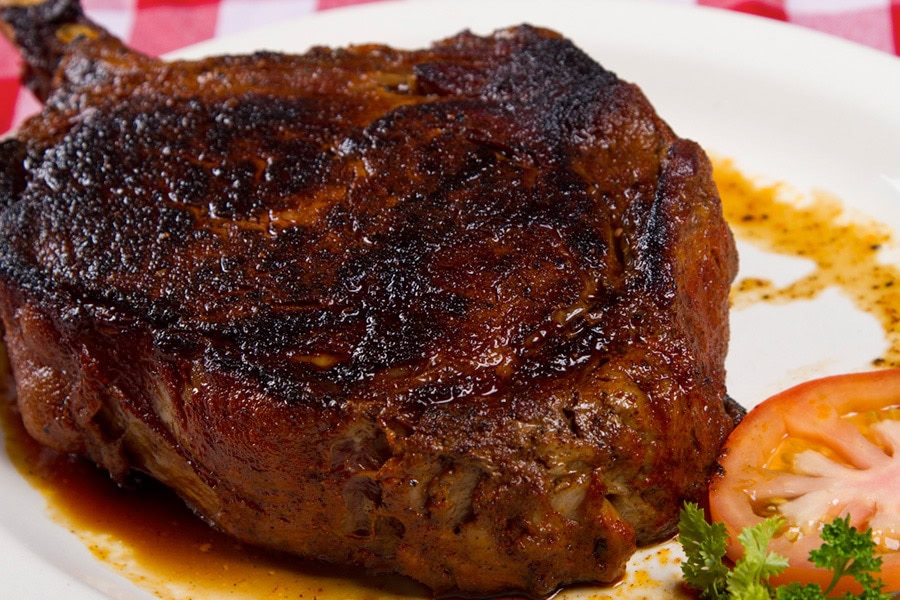 A thick, seasoned bone-in ribeye served at Herman’s Ribhouse